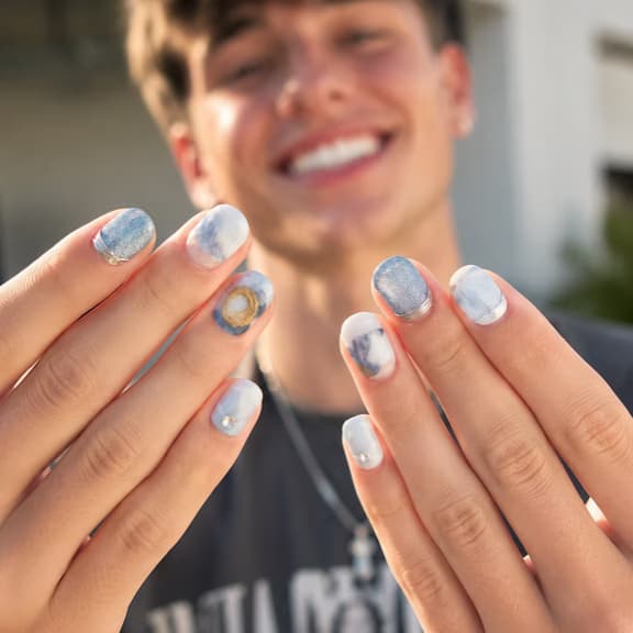 Hands held up showing blue agate marble press-on nails